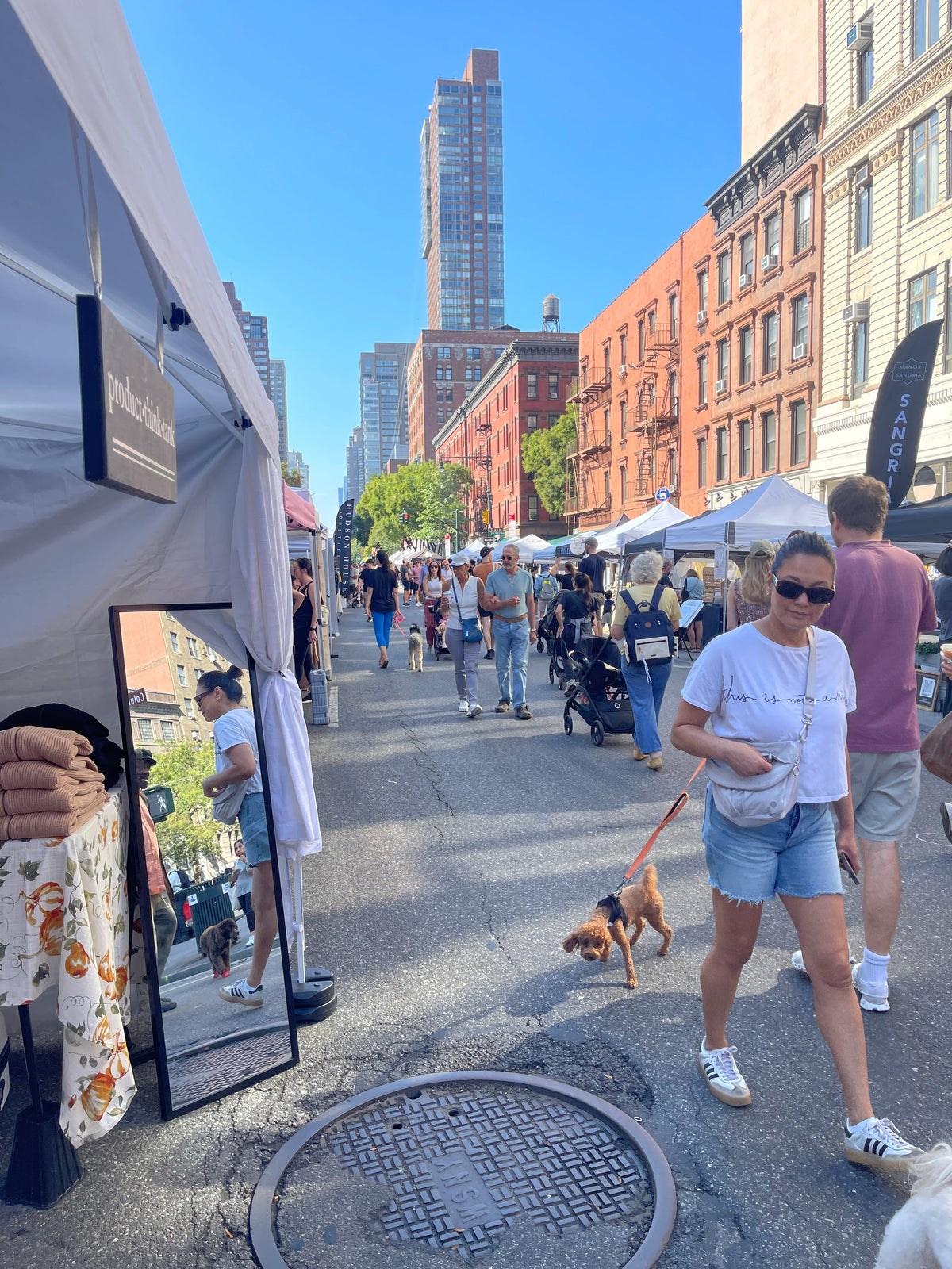 woman walking her dog on Columbus Ave NYC with pop up tents on the street