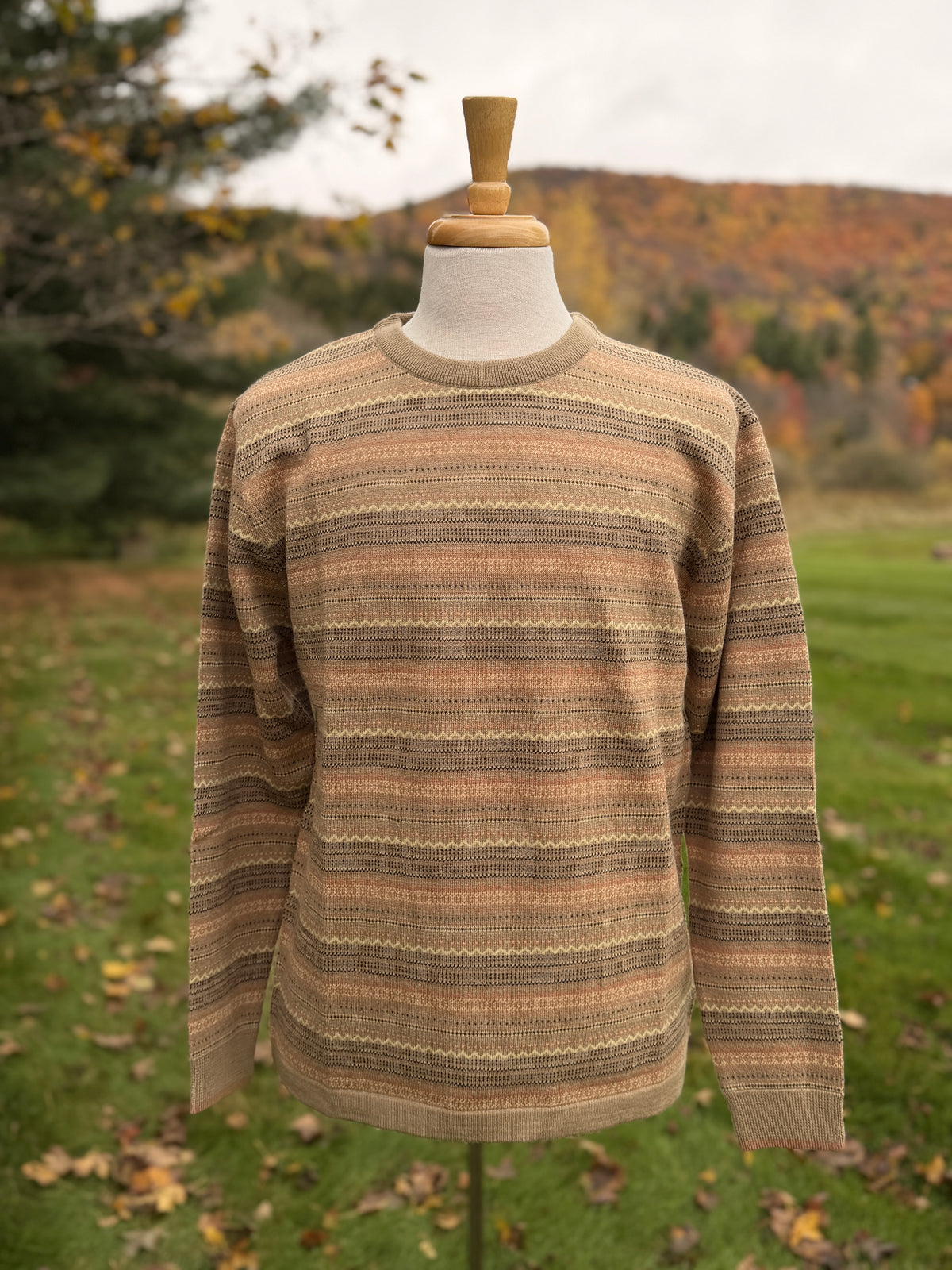 Browns and beige tones allover fairisle sweater on mannequin against grass and tree background