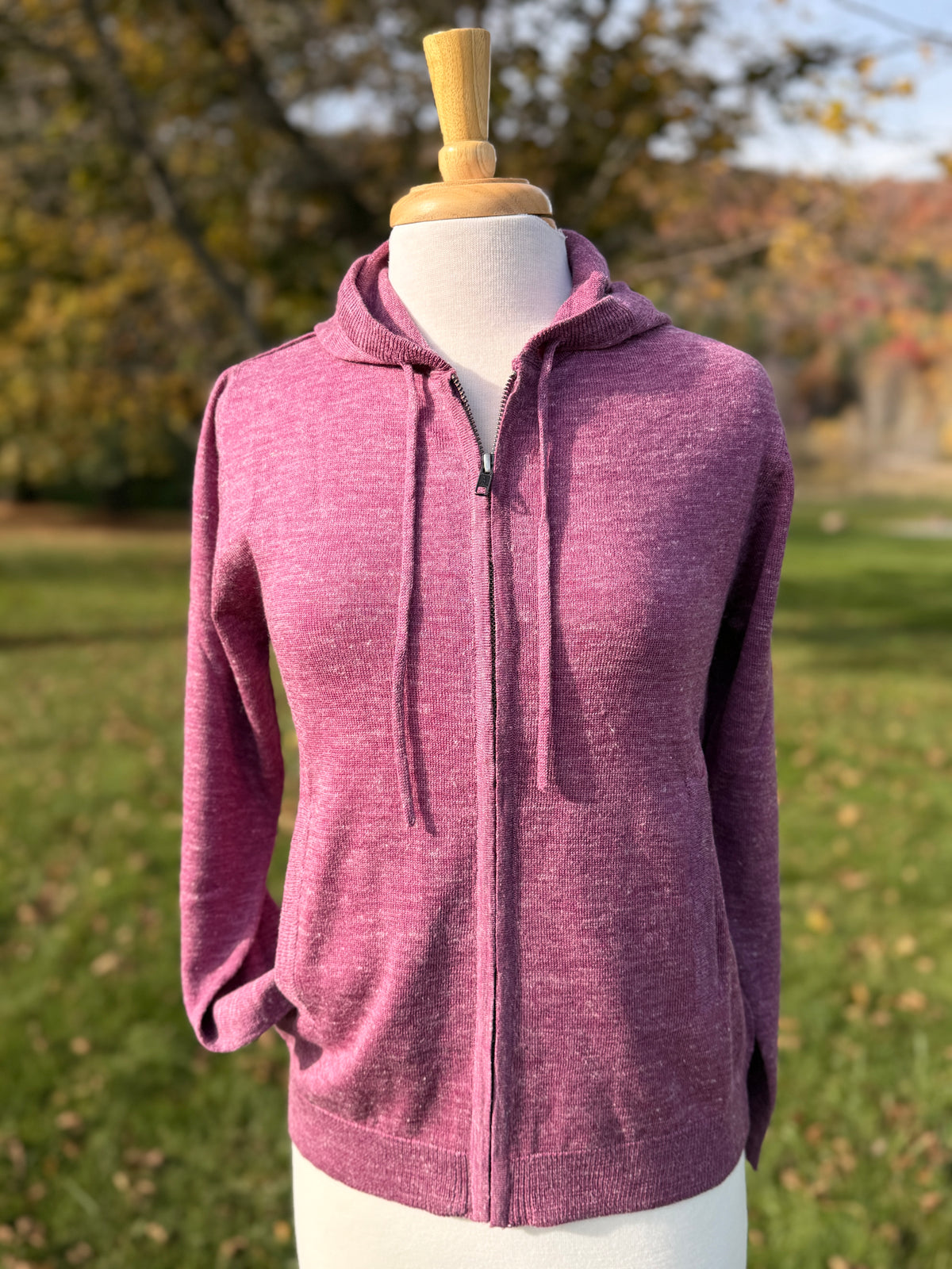 Boysenberry colored wool linen hoodie on mannequin against tree background
