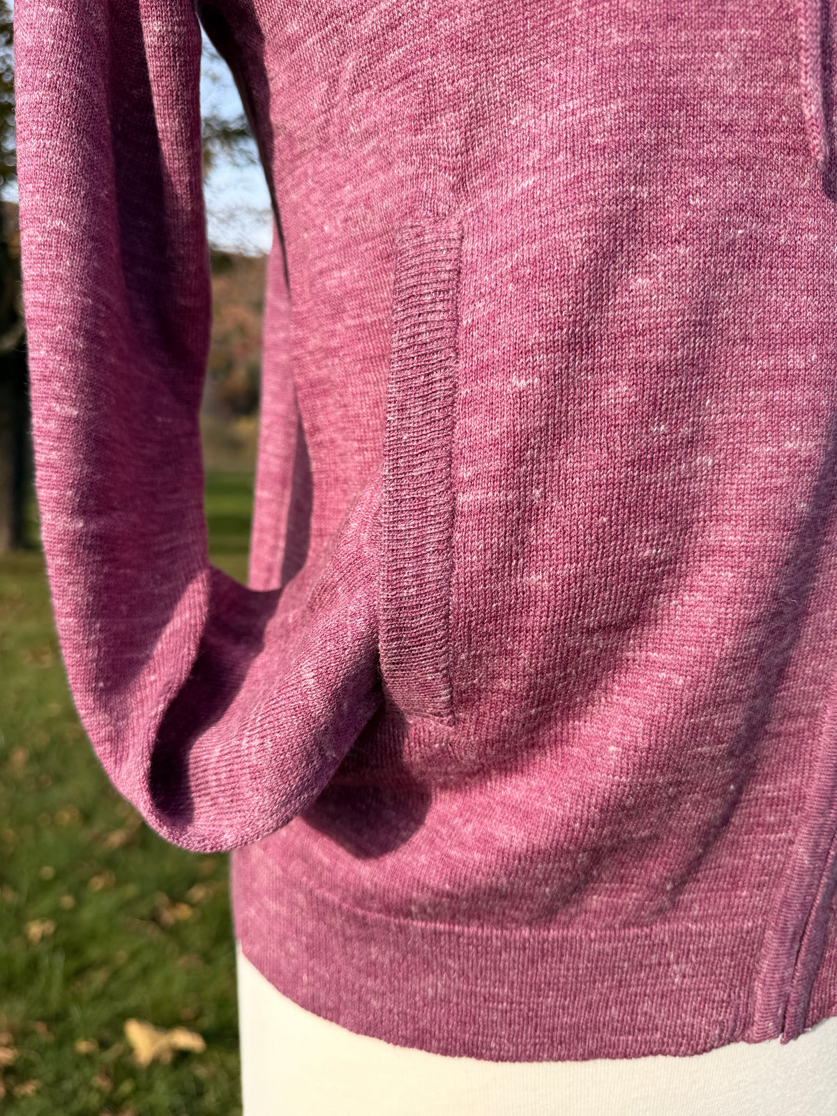 Sleeve in knit pocket to show rib detail at pocket edge and bottom. On Mannequin against grass background