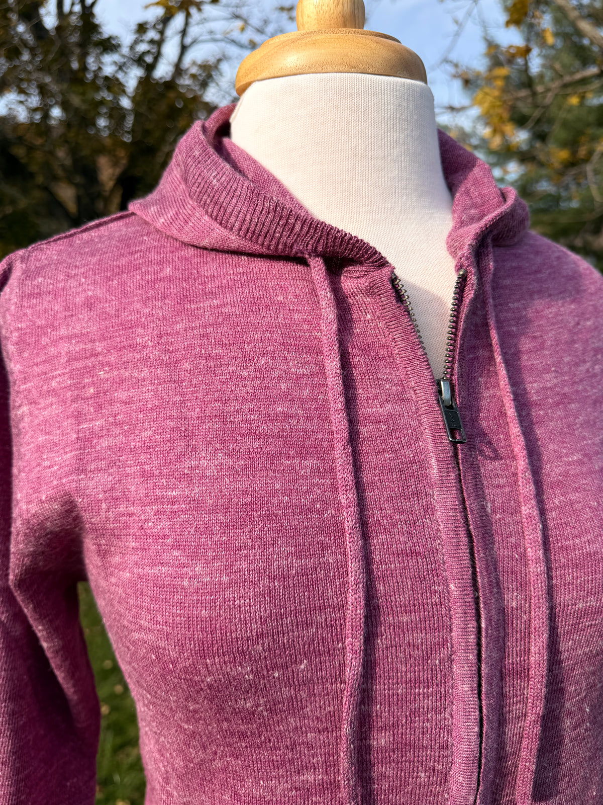Close up of women's wool linen hoodie in Boysenberry color. Ribbed edge on hood with metal zipper and knit drawstrings