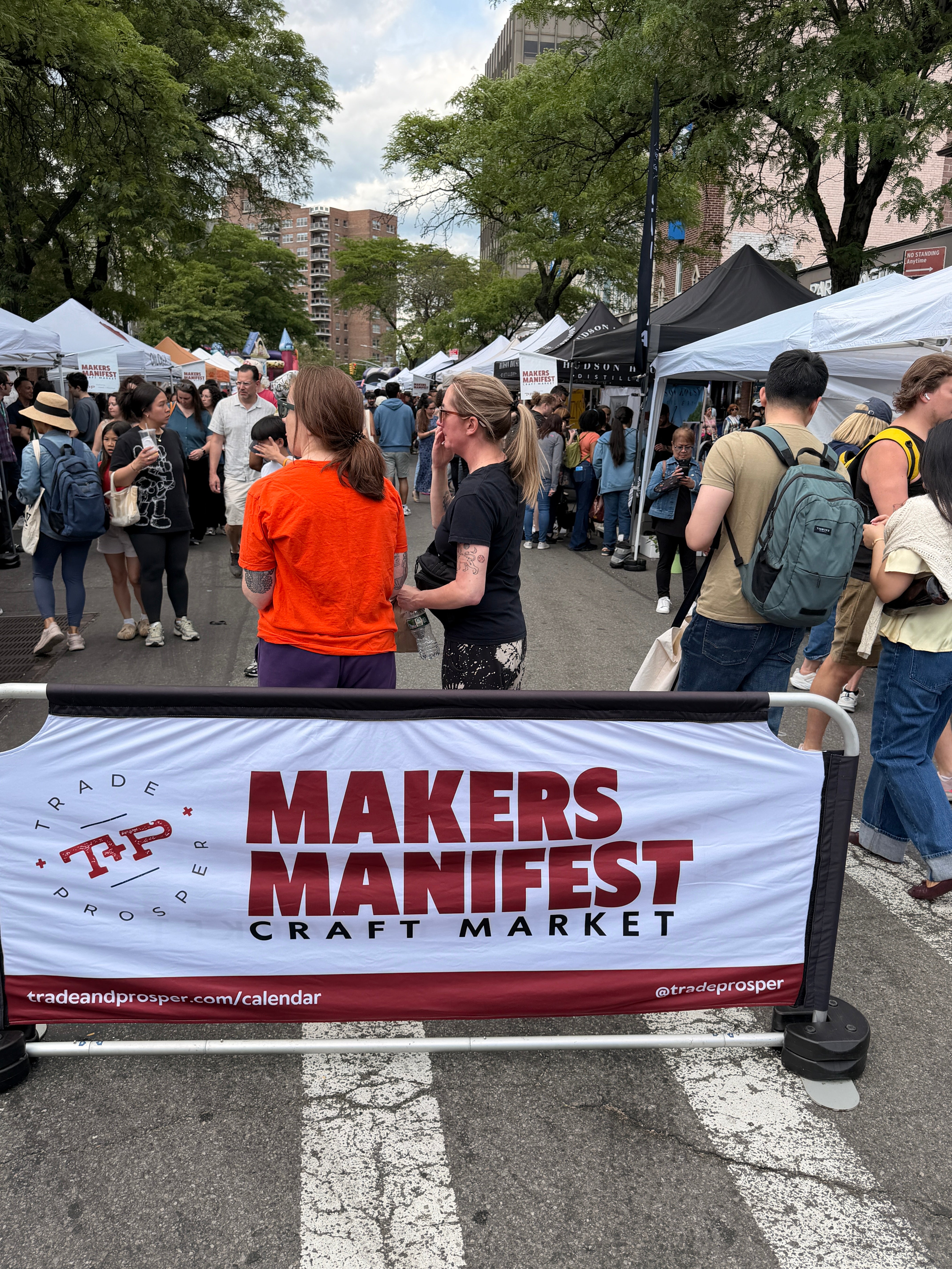 Craft Market sign on street with people on street and pop up tents in Forest Hills NY