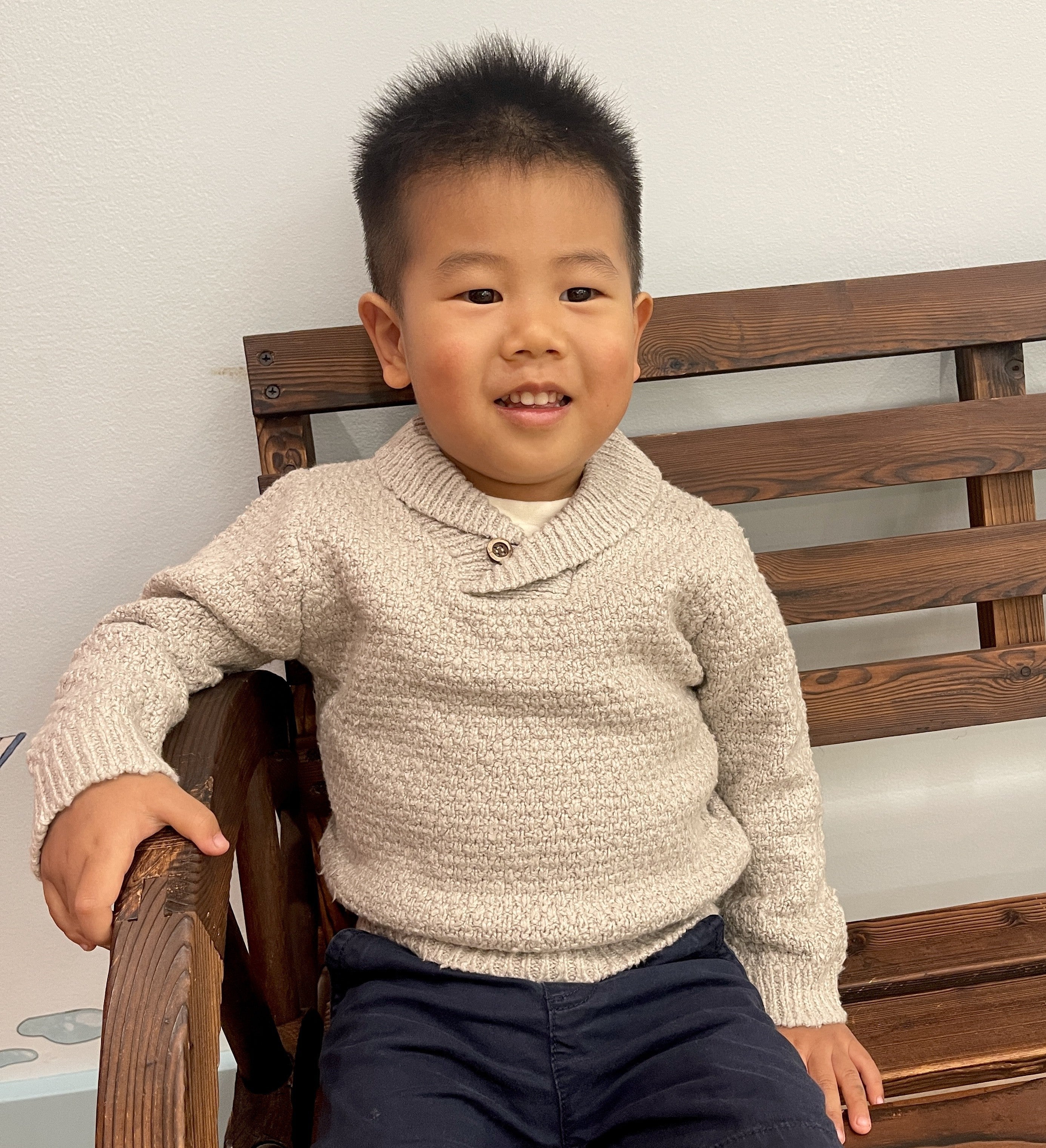 Baby in Bubblegum pink cardigan with wood buttons laying on grass 